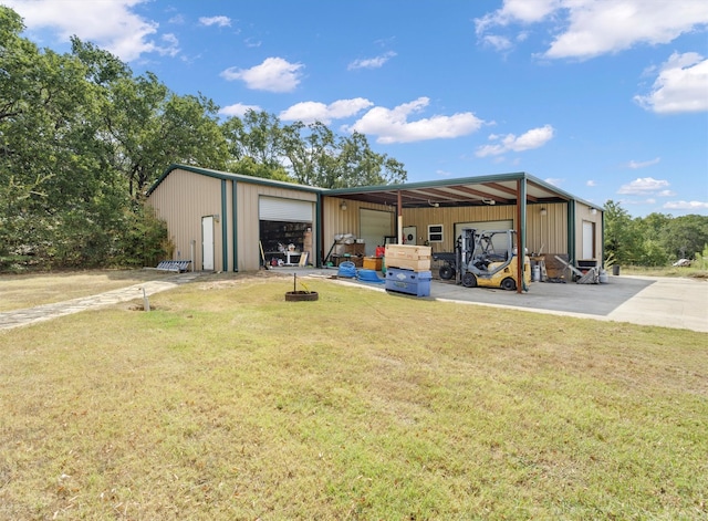 rear view of property with a lawn, an outbuilding, and a garage