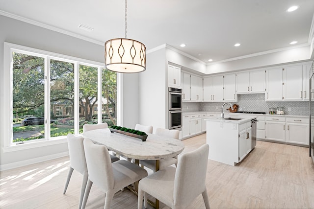 dining space featuring crown molding, light hardwood / wood-style floors, and plenty of natural light