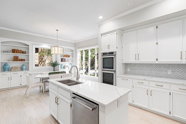 kitchen featuring a wealth of natural light, white cabinets, appliances with stainless steel finishes, and sink