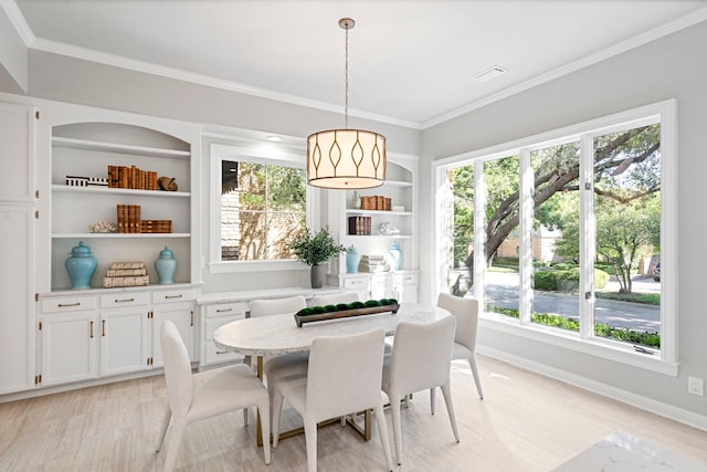 dining room featuring light hardwood / wood-style floors, plenty of natural light, and crown molding