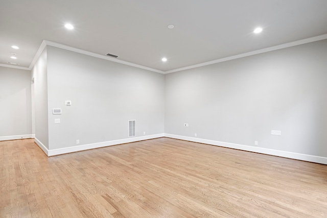 spare room featuring light wood-type flooring and ornamental molding