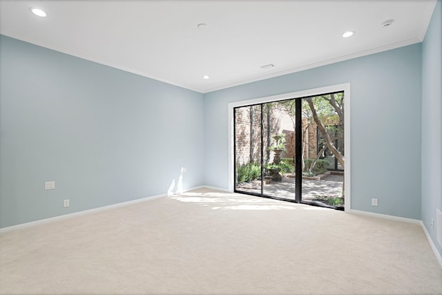 carpeted spare room featuring crown molding