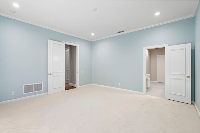 interior space featuring light carpet, connected bathroom, and ornamental molding