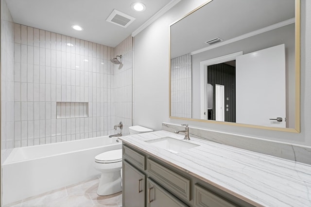 full bathroom with tile patterned floors, crown molding, vanity, tiled shower / bath, and toilet