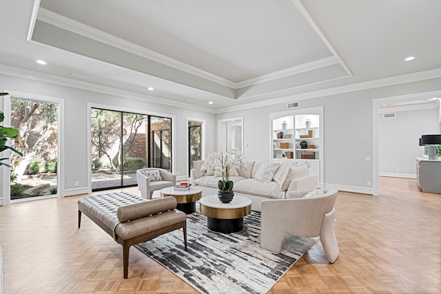 living room with ornamental molding, a tray ceiling, and light parquet floors