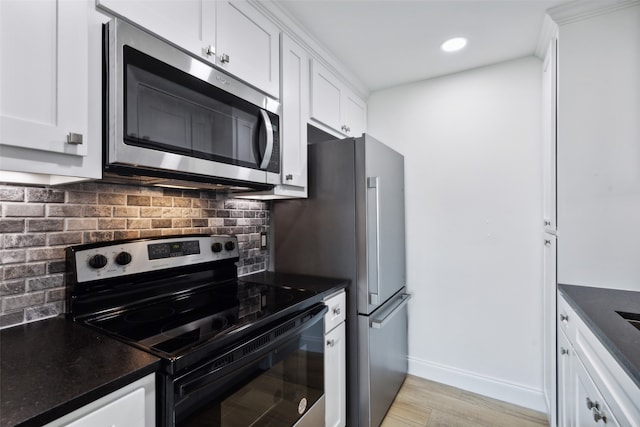 kitchen featuring white cabinets, stainless steel appliances, backsplash, and light hardwood / wood-style floors