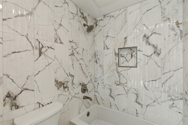 bathroom with tile walls, tiled shower / bath combo, and toilet