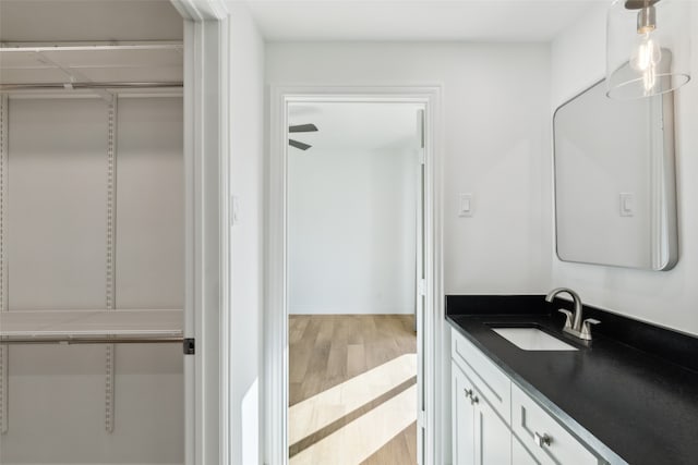 bathroom with wood-type flooring, vanity, and ceiling fan