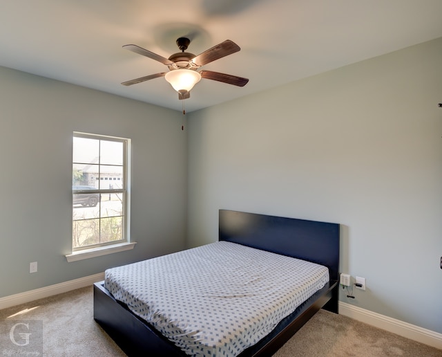 bedroom with ceiling fan and light carpet