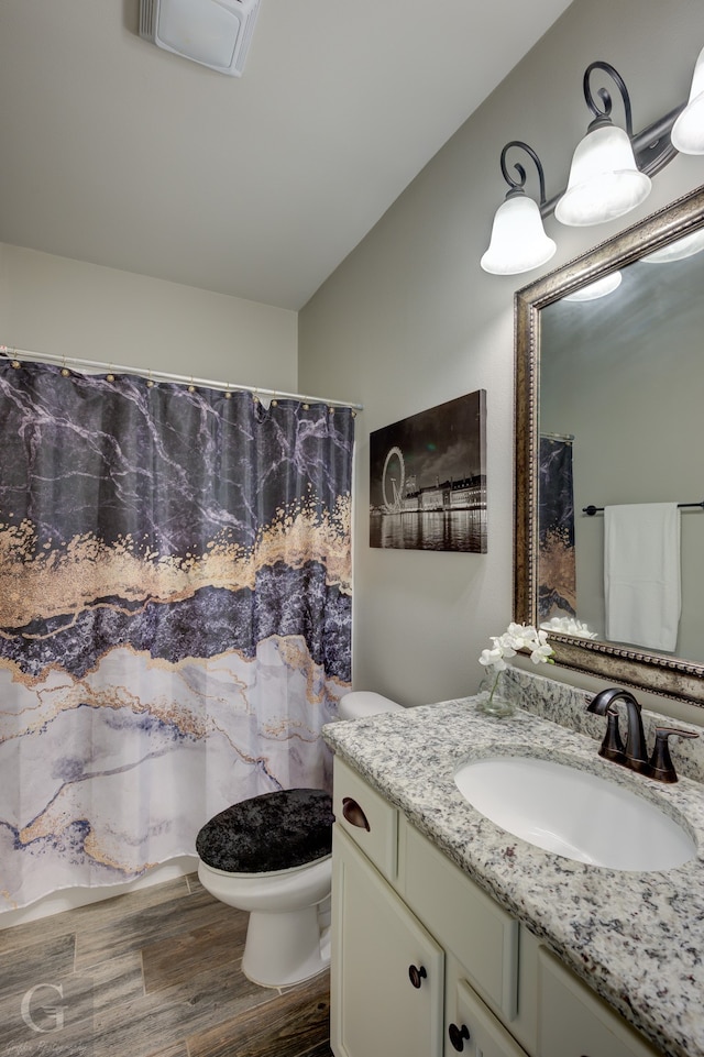 bathroom featuring vanity, toilet, hardwood / wood-style floors, curtained shower, and vaulted ceiling