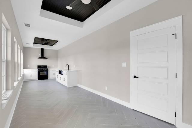 unfurnished living room with light parquet flooring, sink, and ceiling fan