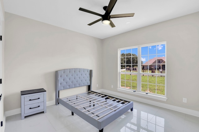 tiled bedroom featuring ceiling fan