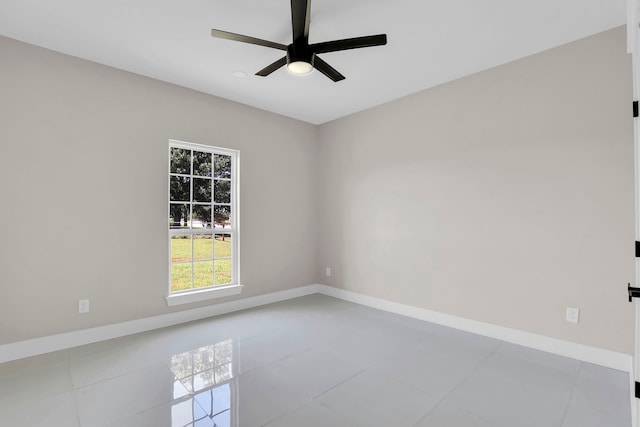 tiled empty room featuring ceiling fan