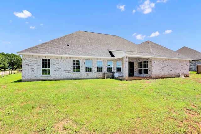 back of property featuring a lawn