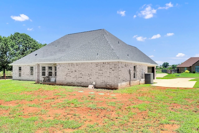 view of property exterior with a patio, a yard, and central AC