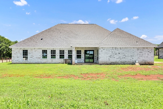 rear view of property with a yard