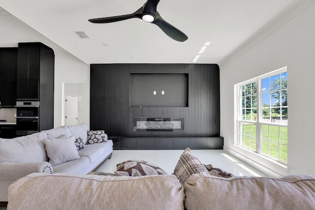 tiled living room featuring ceiling fan and crown molding