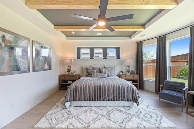 bedroom featuring ceiling fan, light hardwood / wood-style flooring, and beam ceiling