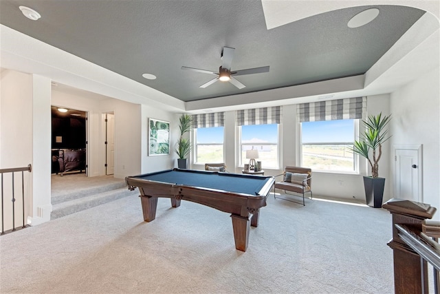 rec room with a wealth of natural light, a textured ceiling, light colored carpet, and ceiling fan