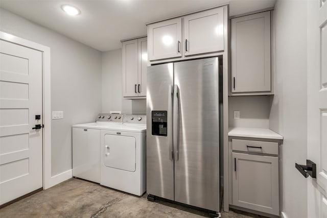 clothes washing area with cabinets and separate washer and dryer