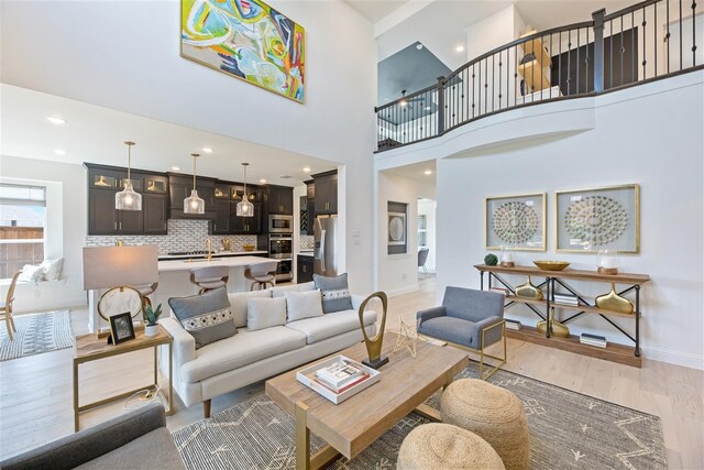 living room featuring light hardwood / wood-style flooring and a towering ceiling