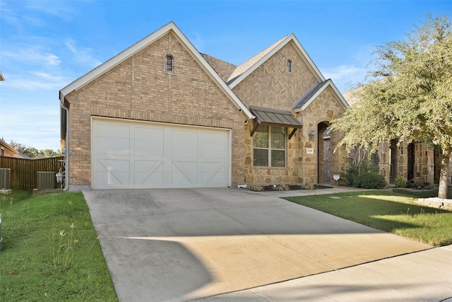 view of front of house featuring a garage, a front yard, and central AC unit