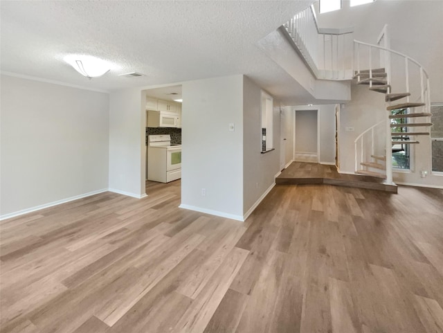 313 Oak Shadow Cir, Bedford, TX 76021 - unfurnished living room featuring stairway, wood finished floors, visible vents, baseboards, and a textured ceiling