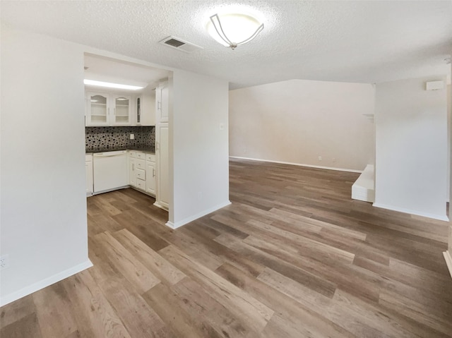 313 Oak Shadow Cir, Bedford, TX 76021 - unfurnished dining area featuring baseboards, light wood-style floors, visible vents, and a textured ceiling