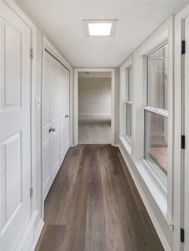 hallway featuring a textured ceiling and dark hardwood / wood-style flooring