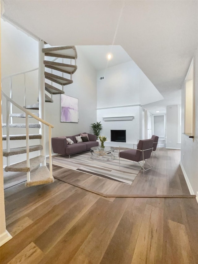 313 Oak Shadow Cir, Bedford, TX 76021 - living room featuring wood finished floors, stairs, a fireplace with raised hearth, baseboards, and visible vents