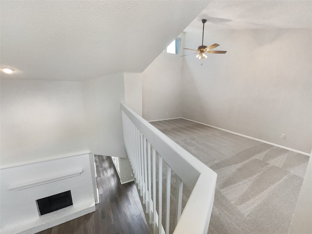 stairs featuring ceiling fan, a textured ceiling, and wood-type flooring