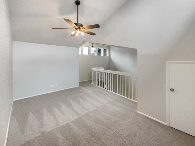 interior space featuring ceiling fan, carpet floors, and lofted ceiling