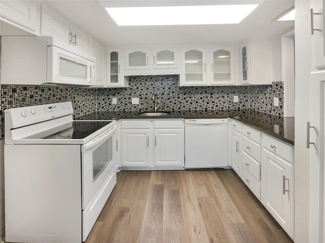 kitchen featuring backsplash, light hardwood / wood-style floors, white appliances, and white cabinetry