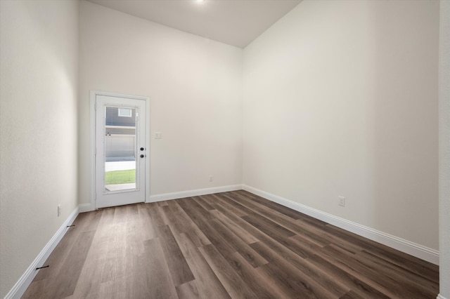 empty room featuring high vaulted ceiling and dark hardwood / wood-style floors