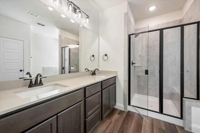 bathroom featuring vanity, hardwood / wood-style flooring, and a shower with door