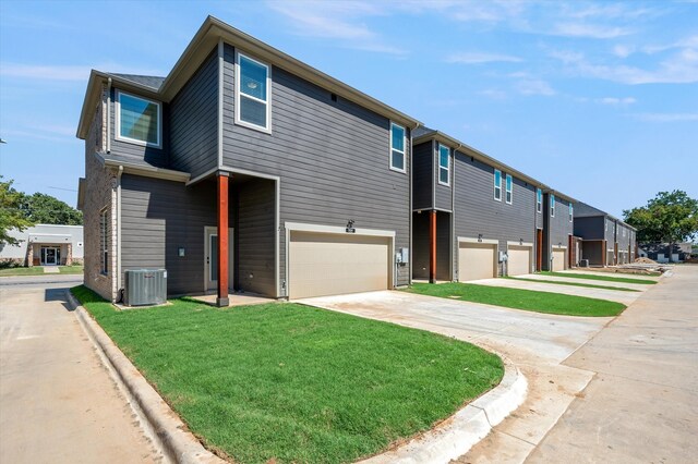 exterior space with central AC, a garage, and a lawn