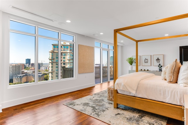 bedroom featuring multiple windows, access to outside, and hardwood / wood-style floors