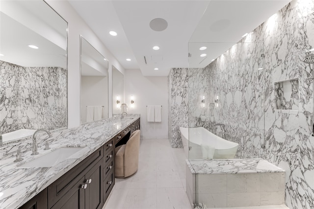 bathroom featuring tile walls, vanity, and a bathtub