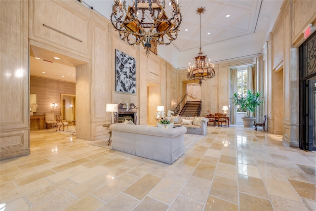 living room with an inviting chandelier, a towering ceiling, and coffered ceiling