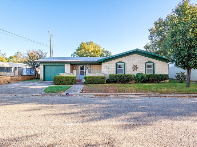 view of front of house with aphalt driveway, a front yard, brick siding, and an attached garage