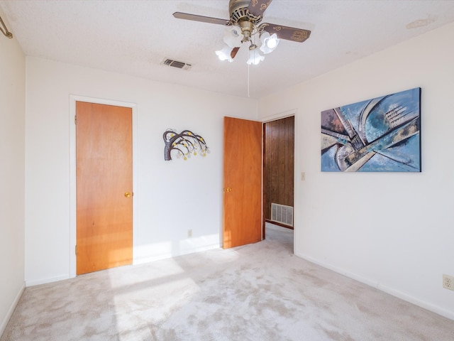 unfurnished bedroom with baseboards, visible vents, and light colored carpet