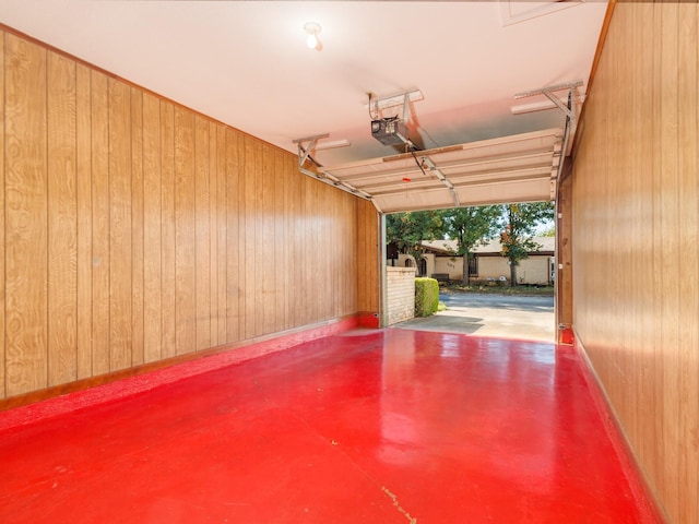 garage with wood walls, baseboards, and a garage door opener