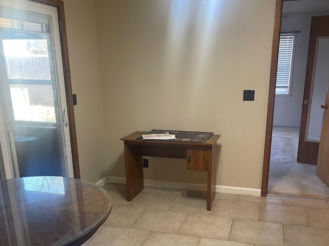 interior space with light tile patterned floors and baseboards