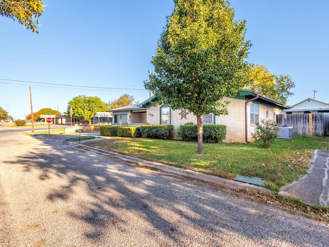 view of front of property with brick siding, a front lawn, fence, and a residential view