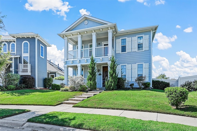 neoclassical home featuring a balcony, a front lawn, and a porch