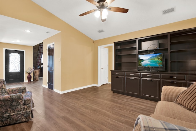 living room featuring lofted ceiling, ceiling fan, and dark wood-type flooring