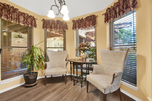 living area with an inviting chandelier and hardwood / wood-style floors