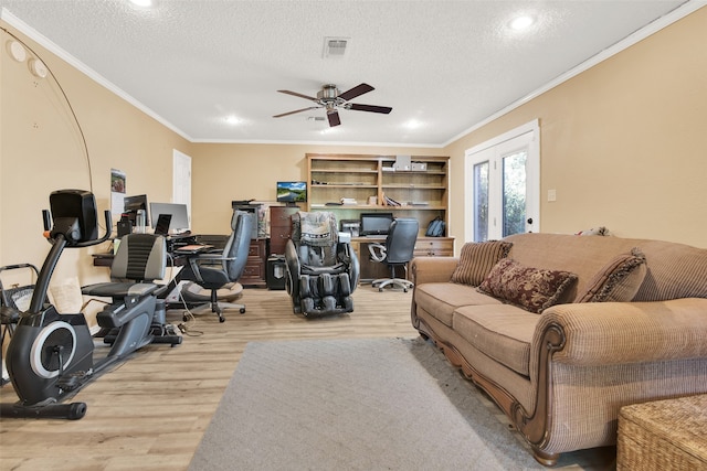 living room featuring ceiling fan, a textured ceiling, crown molding, and light hardwood / wood-style floors