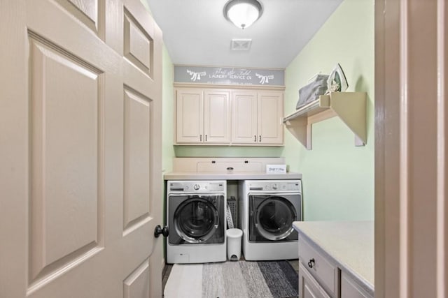 clothes washing area featuring cabinets and independent washer and dryer