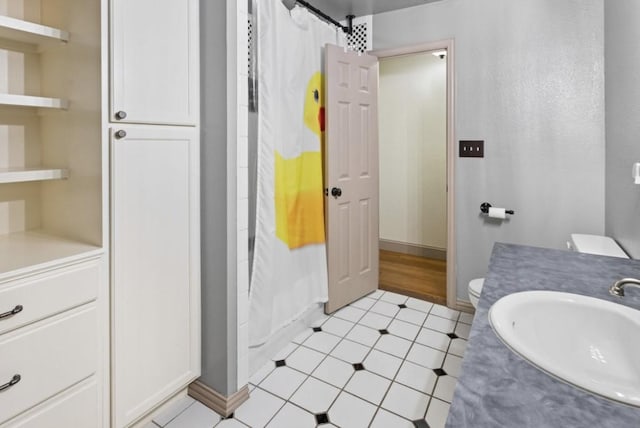 bathroom with tile patterned flooring, vanity, and toilet